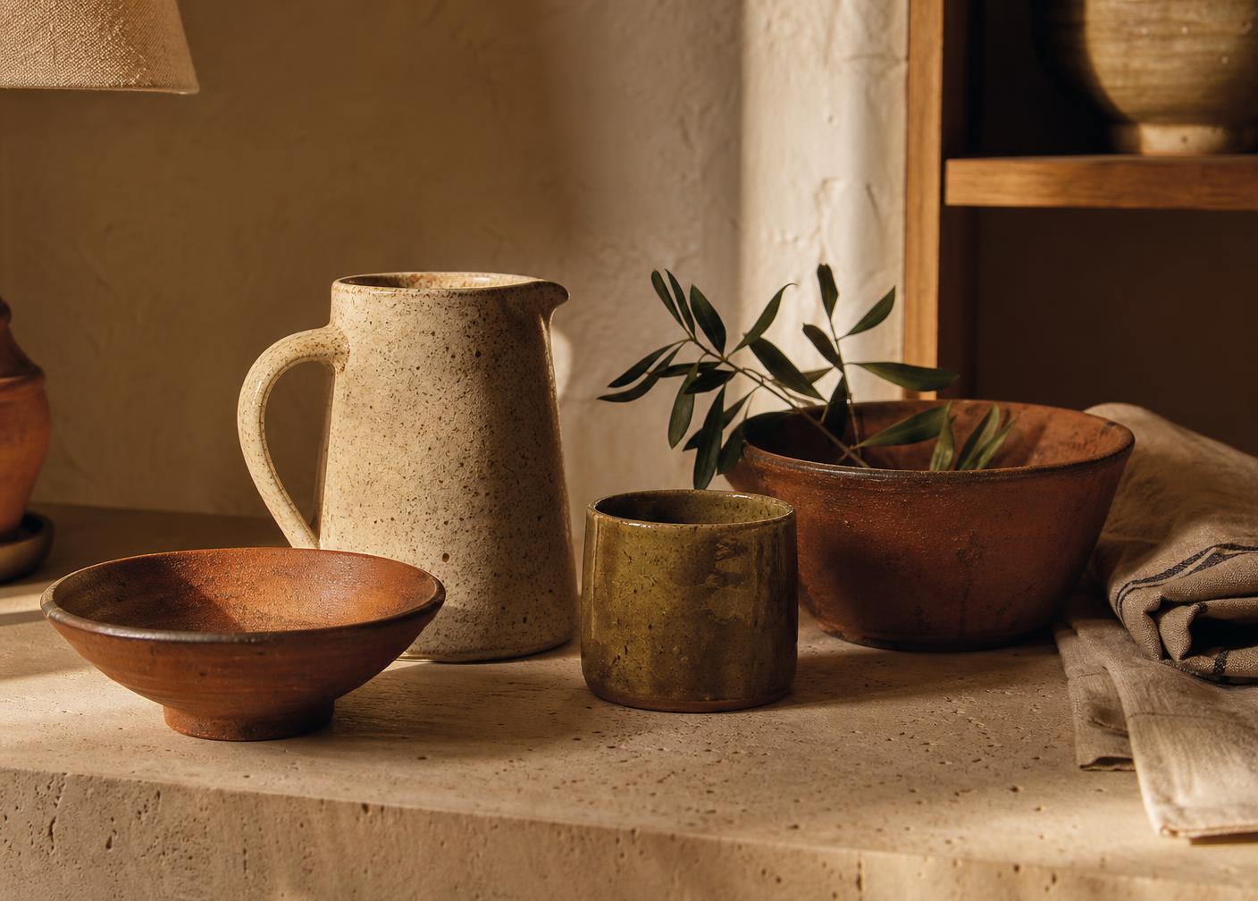 Hand-thrown terracotta and stoneware on a travertine ledge